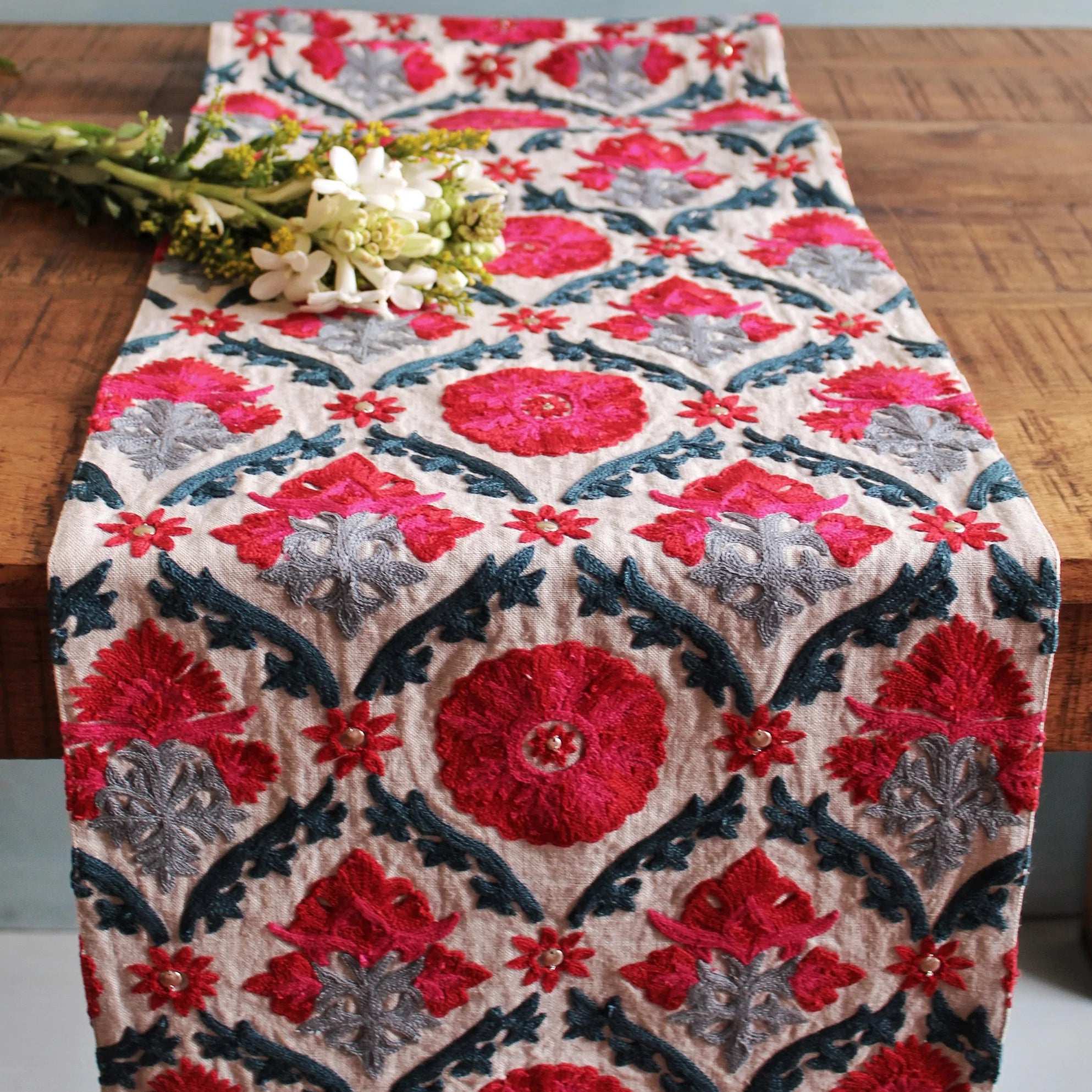 Suzani Niksaar linen table runner in red, pink and blue with corner tassels