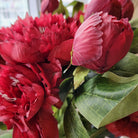 Vivid red artificial flower stem with two blooms and a bud