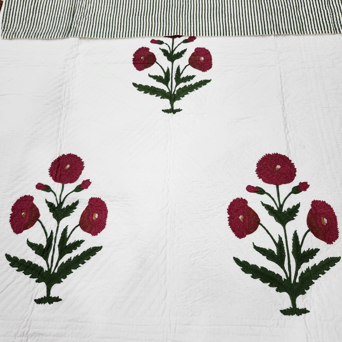 Hand quilted block print bedspread with detailed poppies on a creamy white ground, 100 per cent cotton.