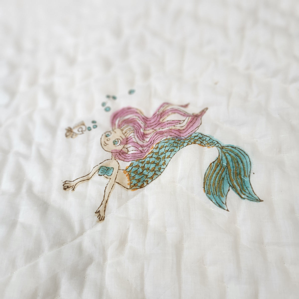 Child's block-print organic cotton quilt with a pretty mermaid print, machine washable, 102 x 152 cm