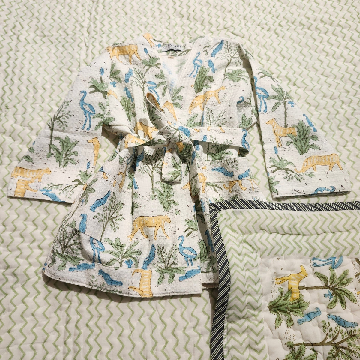 Child's jungle print waffle bath robe shown with the matching child's block print quilt in the same design of cats and birds