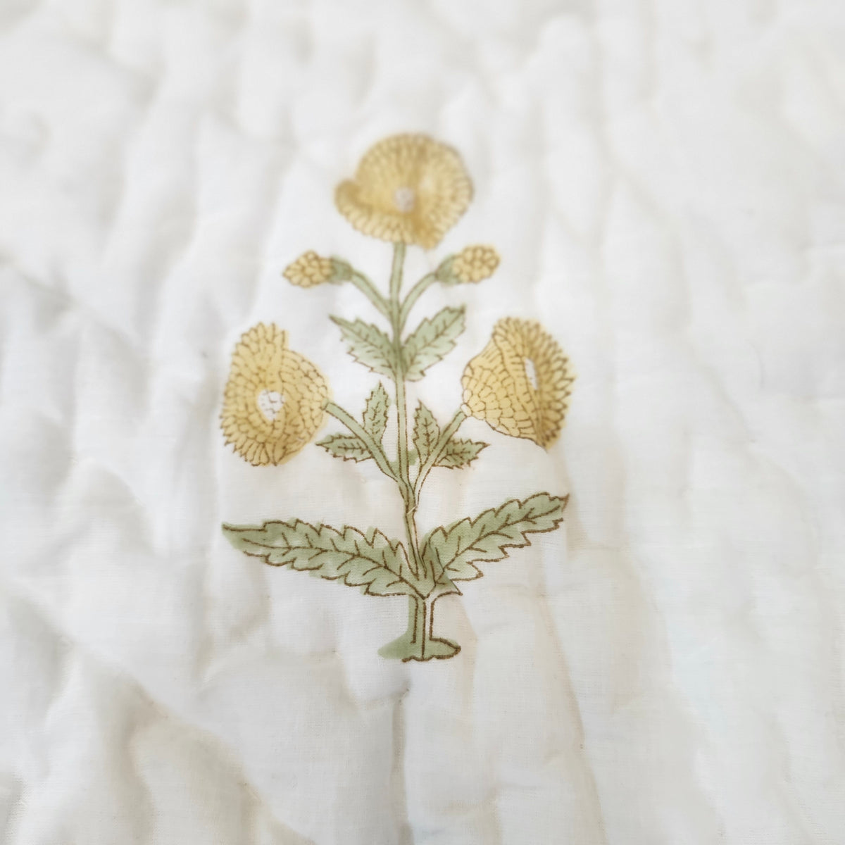 Yellow marigold child's quilt, reverse with a smaller marigold print