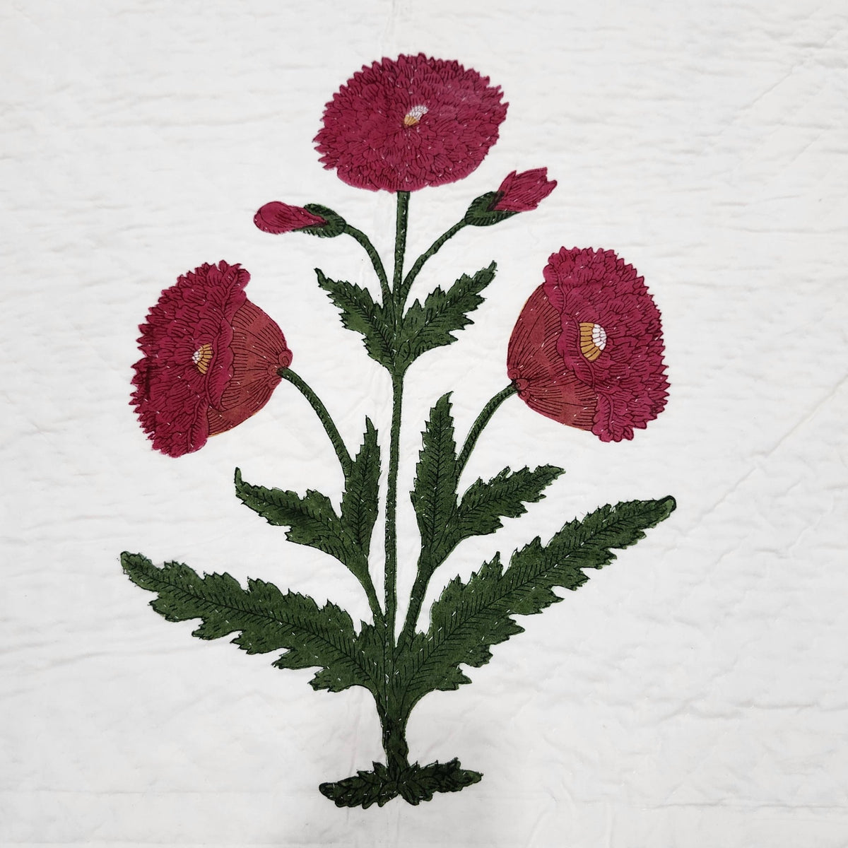 Detail of the poppy block print bedspread, showing the fine hand quilting worked across the cotton.