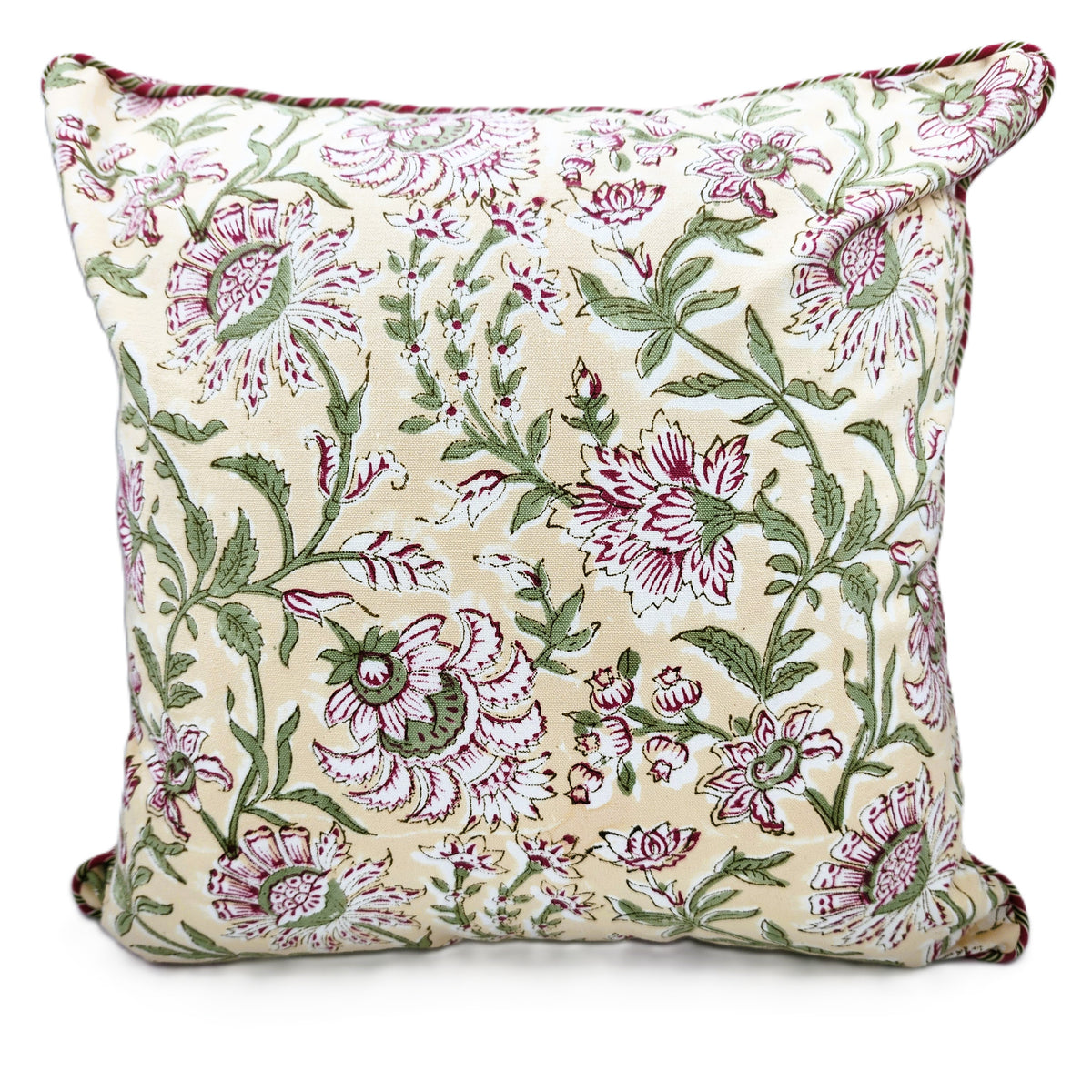 Styled view of the Summer block print cushion, pink flowers on a cream ground, pairing well with white bed linen or a sofa