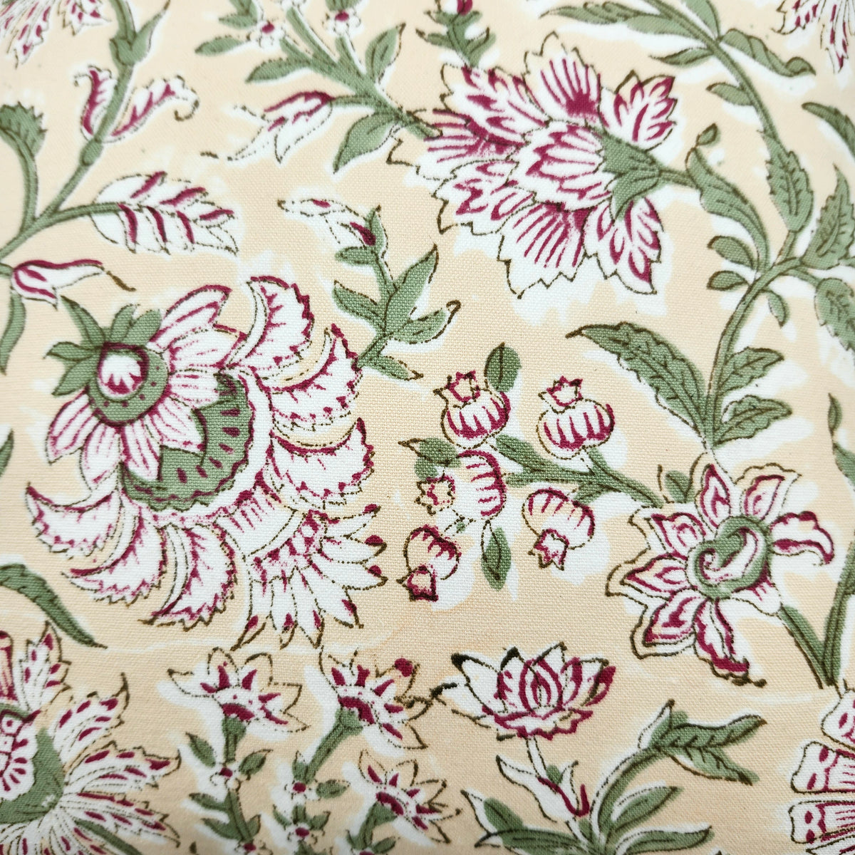 Detail of the deep pink flowers and green leaves on the Summer cushion cover, with the toning striped piping around its edge