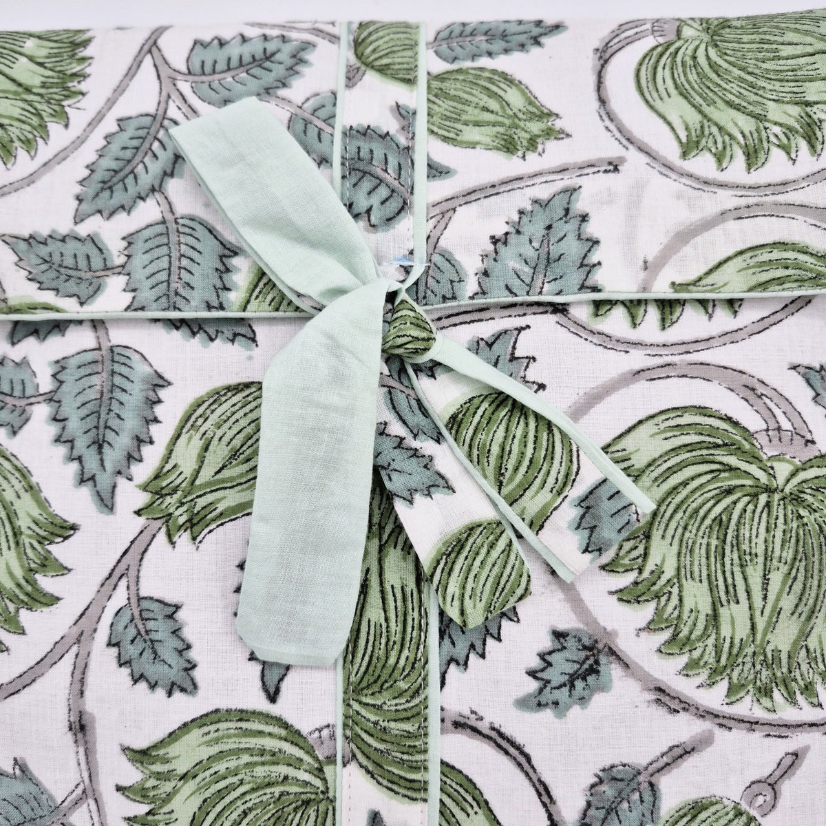 A printed lotus pattern on a fabric envelope containing a pair of pyjamas