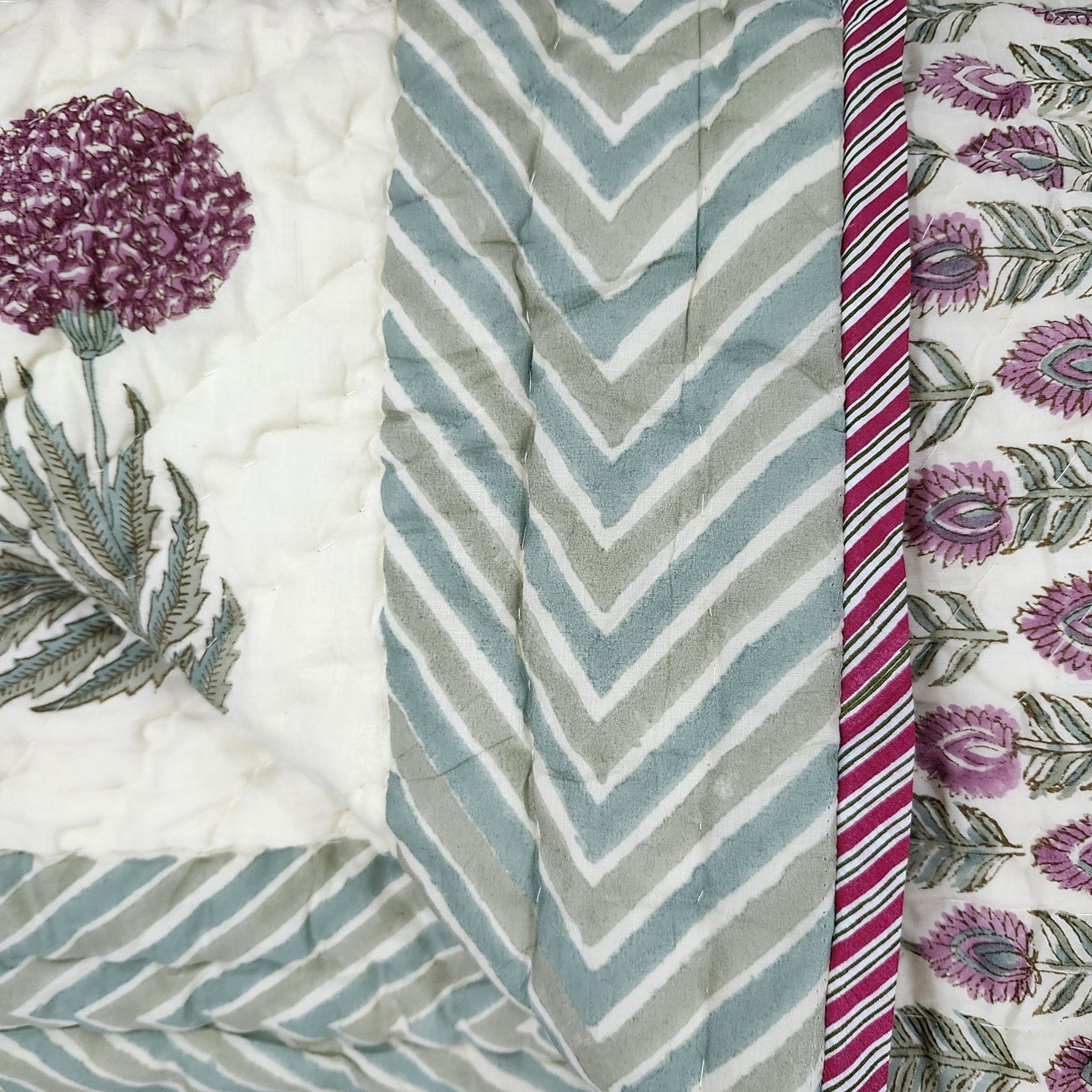 Single block-print quilt, pink flowers on cream with a teal border
