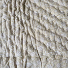 Toddler block-print cotton quilt with beige and white stripes and a white-on-beige floral reverse