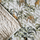 Toddler block-print cotton quilt with a jungle print of giraffes, leopards and hoopoes, made in India