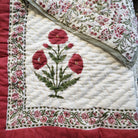 Single block-print quilt with poppies and a floral border in red and green