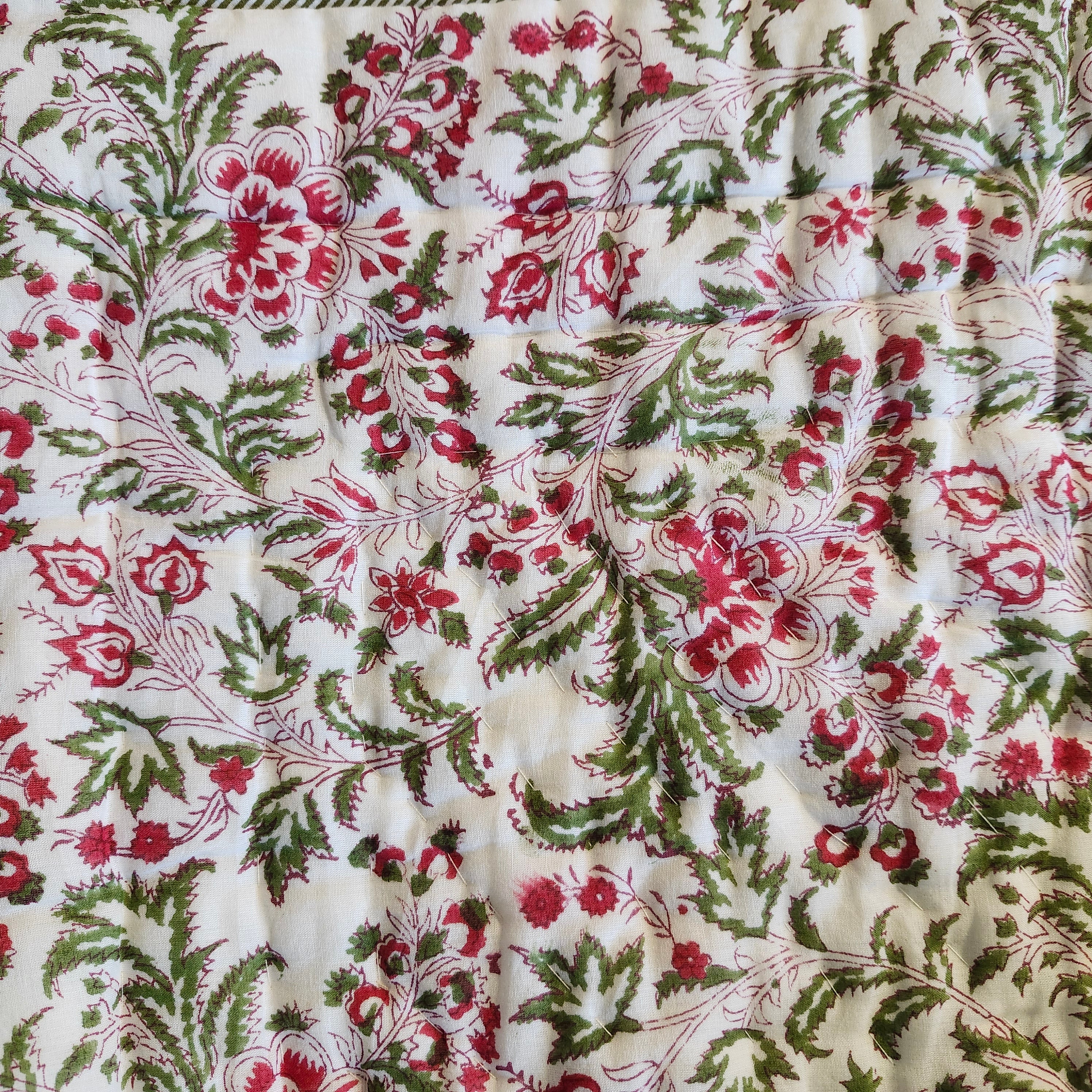 Festive botanical block-print quilt in green and red