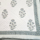 Block-print single quilt with a smaller-scale blue dahlia print on the reverse