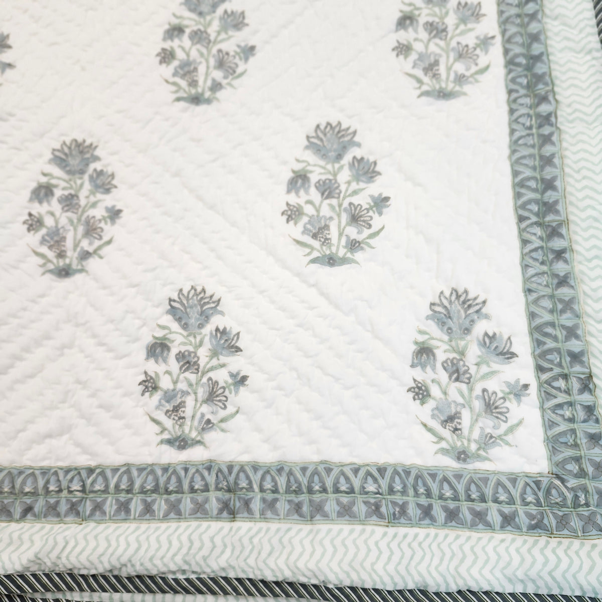 Block-print single quilt with a smaller-scale blue dahlia print on the reverse