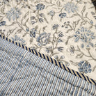 Single block-print quilt in a blue floral pattern with striped reverse