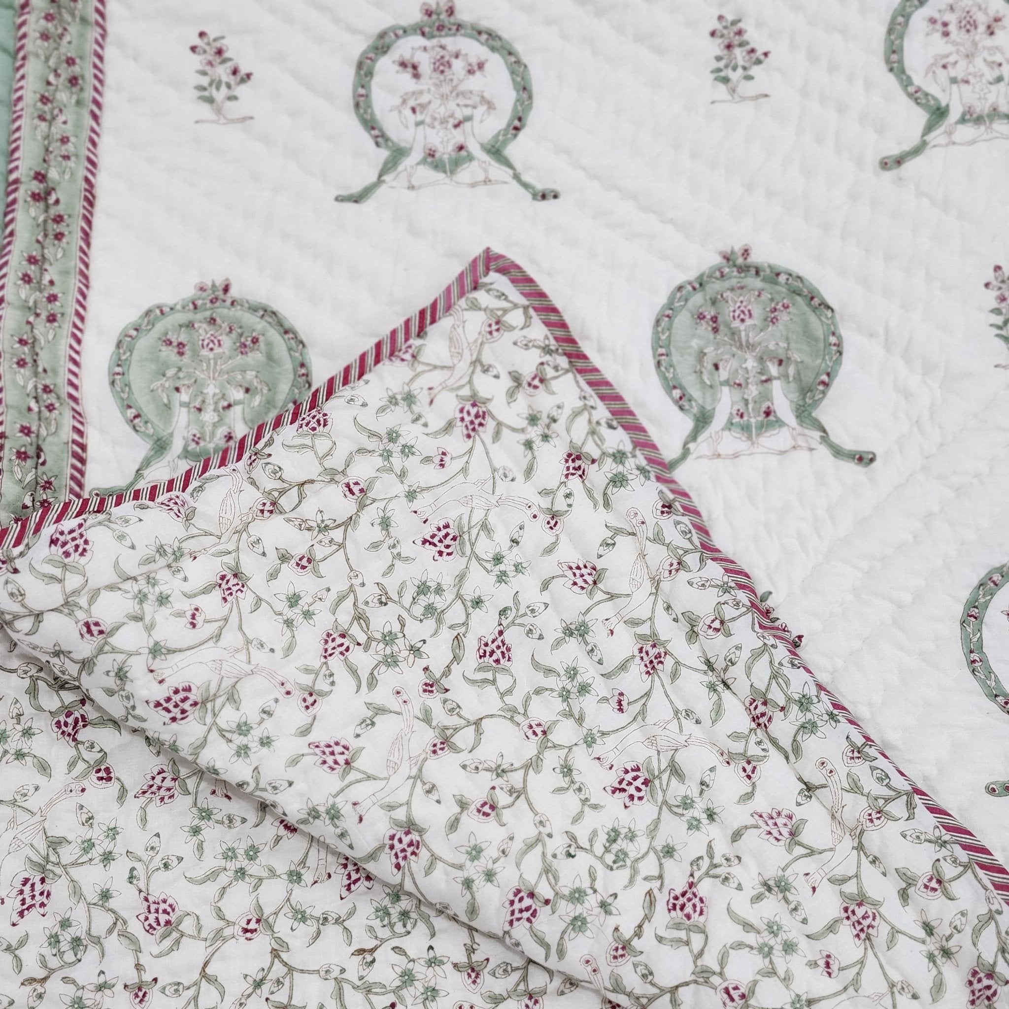 Reversible single block-print cotton quilt with a repeating two-peacock motif, made in India