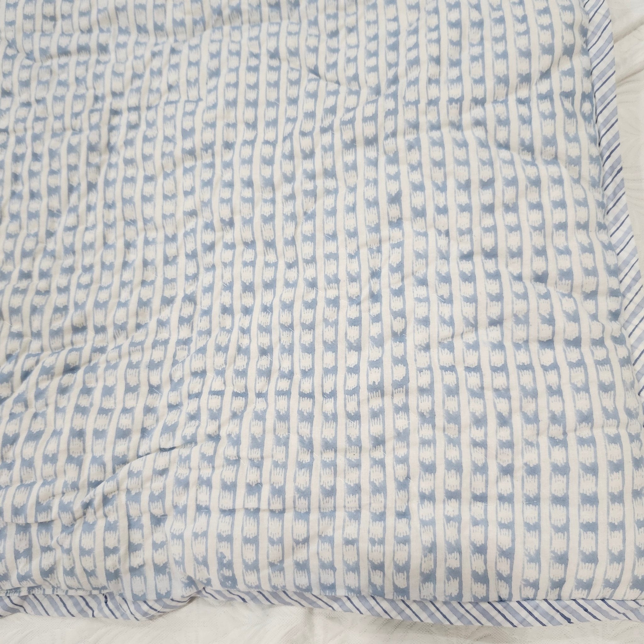 Block-print single quilt, blue and pale pink floral reverse