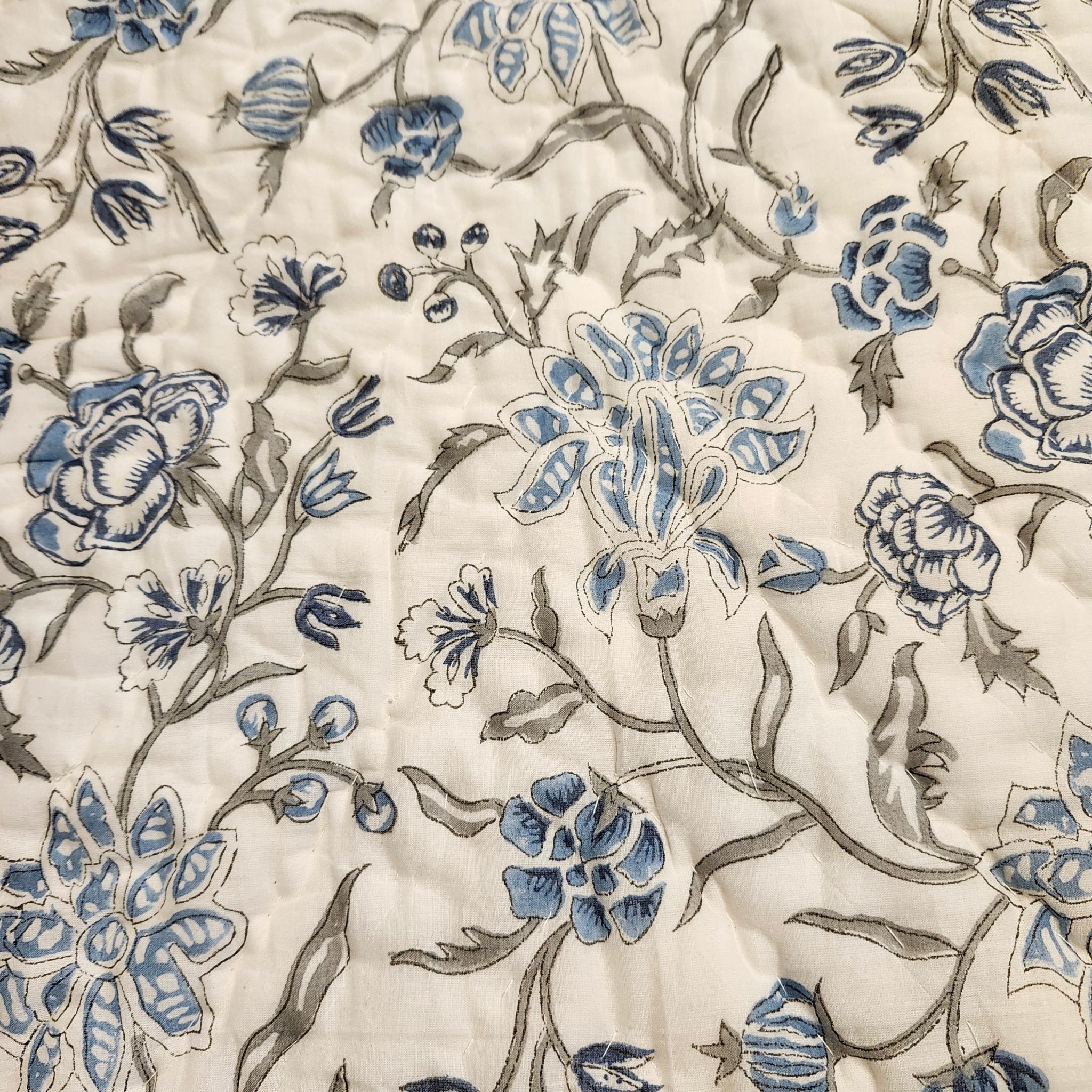 Blue floral block-print quilt with a striped reverse