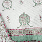 Single block-print quilt with peacocks and a floral reverse, styled on a bed