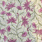 Floral block print table cloth with pink flowers, green leaves and tiny birds on a pale yellow background