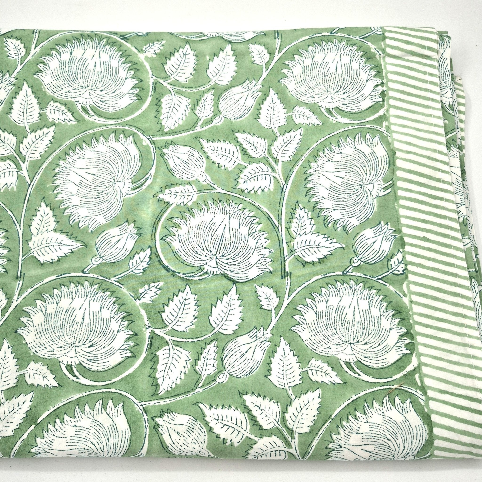 Green block print tablecloth with white lotus pattern and striped edge