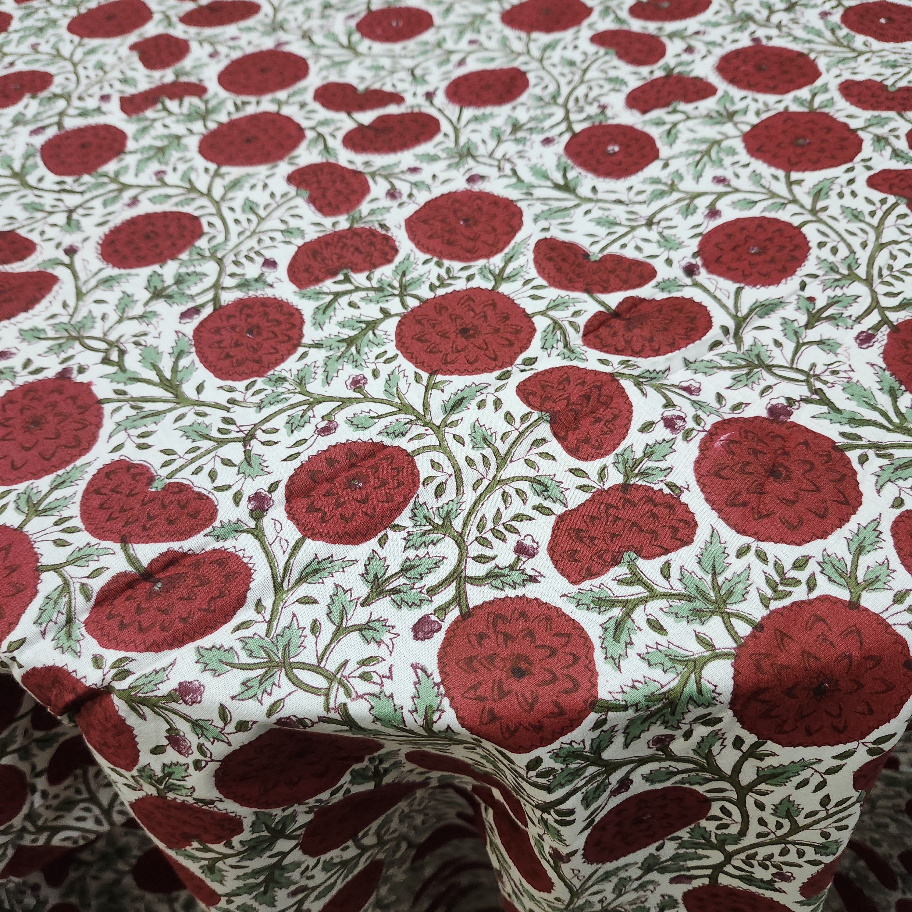 Round block-print cotton tablecloth in a green and red poppy pattern