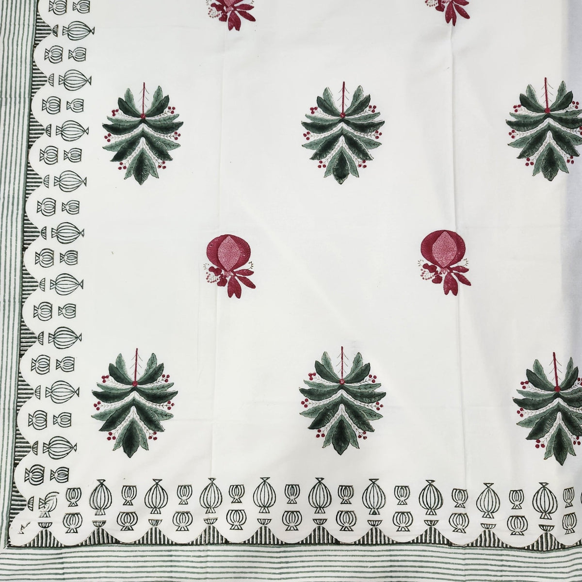 Cotton block print tablecloth with red stemmed palms, coconuts and pomegranates on cream, striped border.