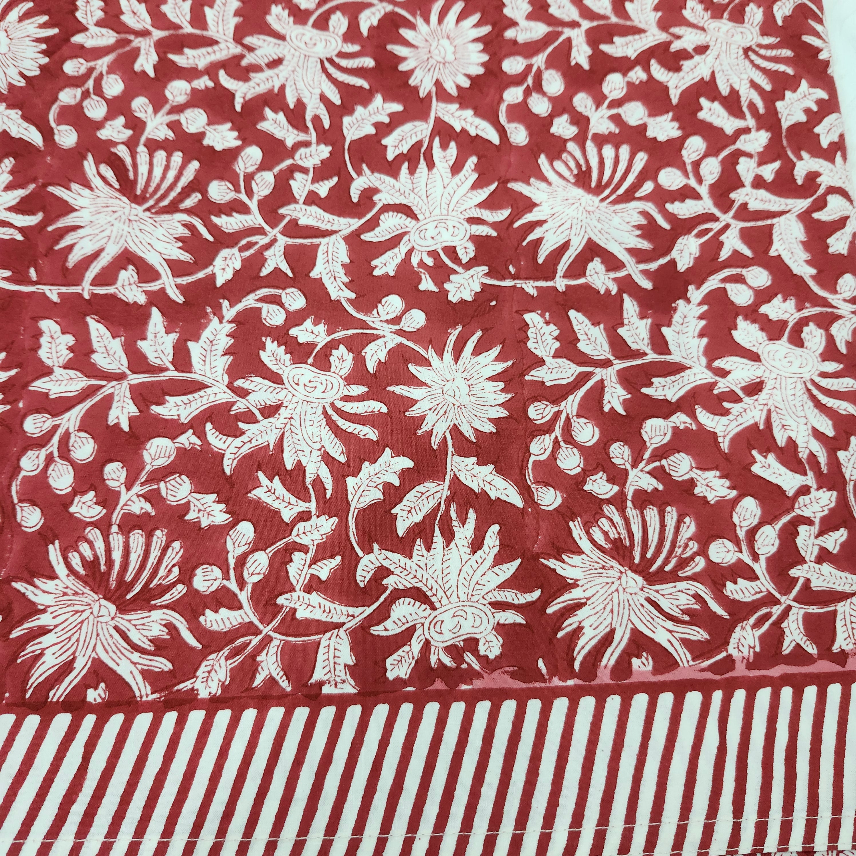 Deep red block-print tablecloth with a striped border
