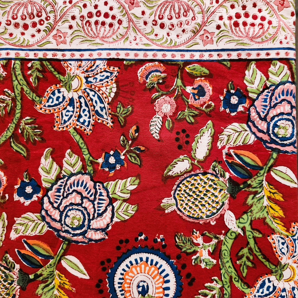 Flavia cotton block print tablecloth with flowers and pomegranates in green foliage and a wide red border, various sizes