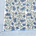 Floral block print tablecloth with blue flowers, green leaves and little birds on a white background