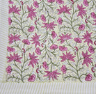 Floral block print table cloth with pink flowers, green leaves and tiny birds on a yellow background