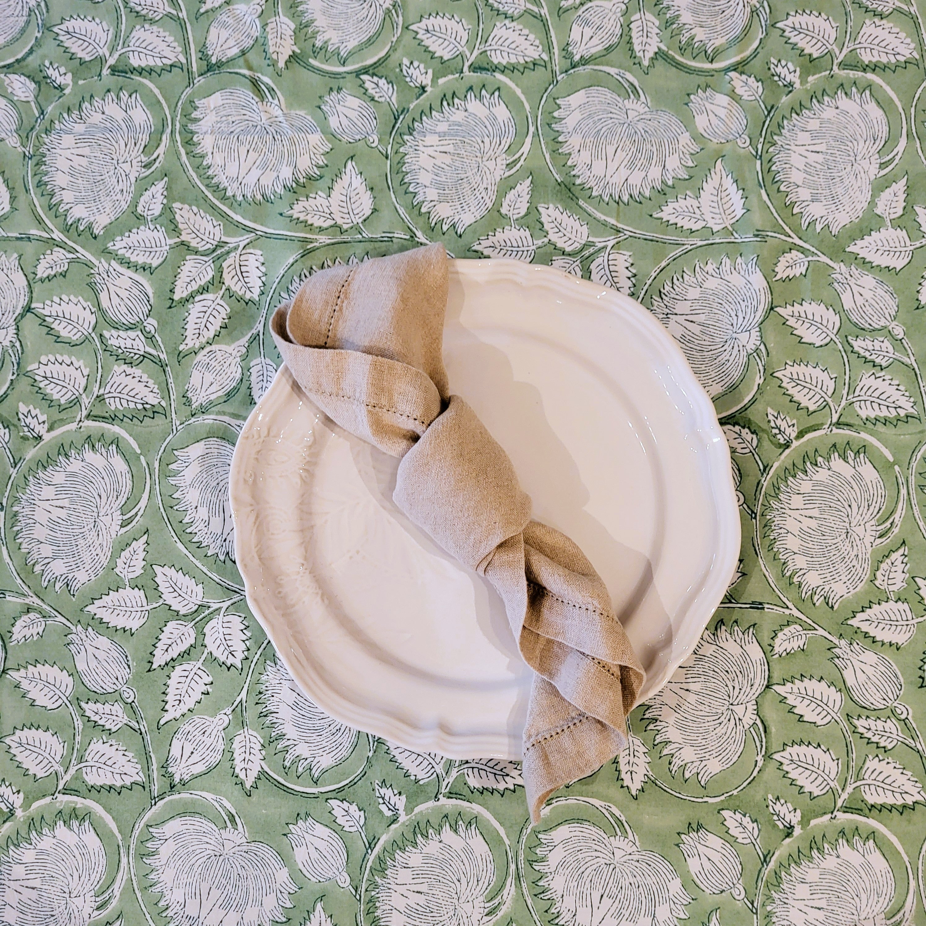 White  Sthal dinner plate with a linen napkin on a pale green lotus block print tablecloth