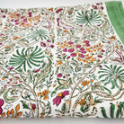 Multicoloured rainforest block-print cotton tablecloth with a green border, each colour added by hand