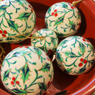 Holly green and white papier-mache Christmas bauble, hand-painted