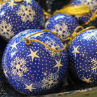 Blue papier-mache Christmas bauble hand-painted with a snowflake design