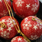 Red papier-mache Christmas bauble hand-painted with a snowflake design