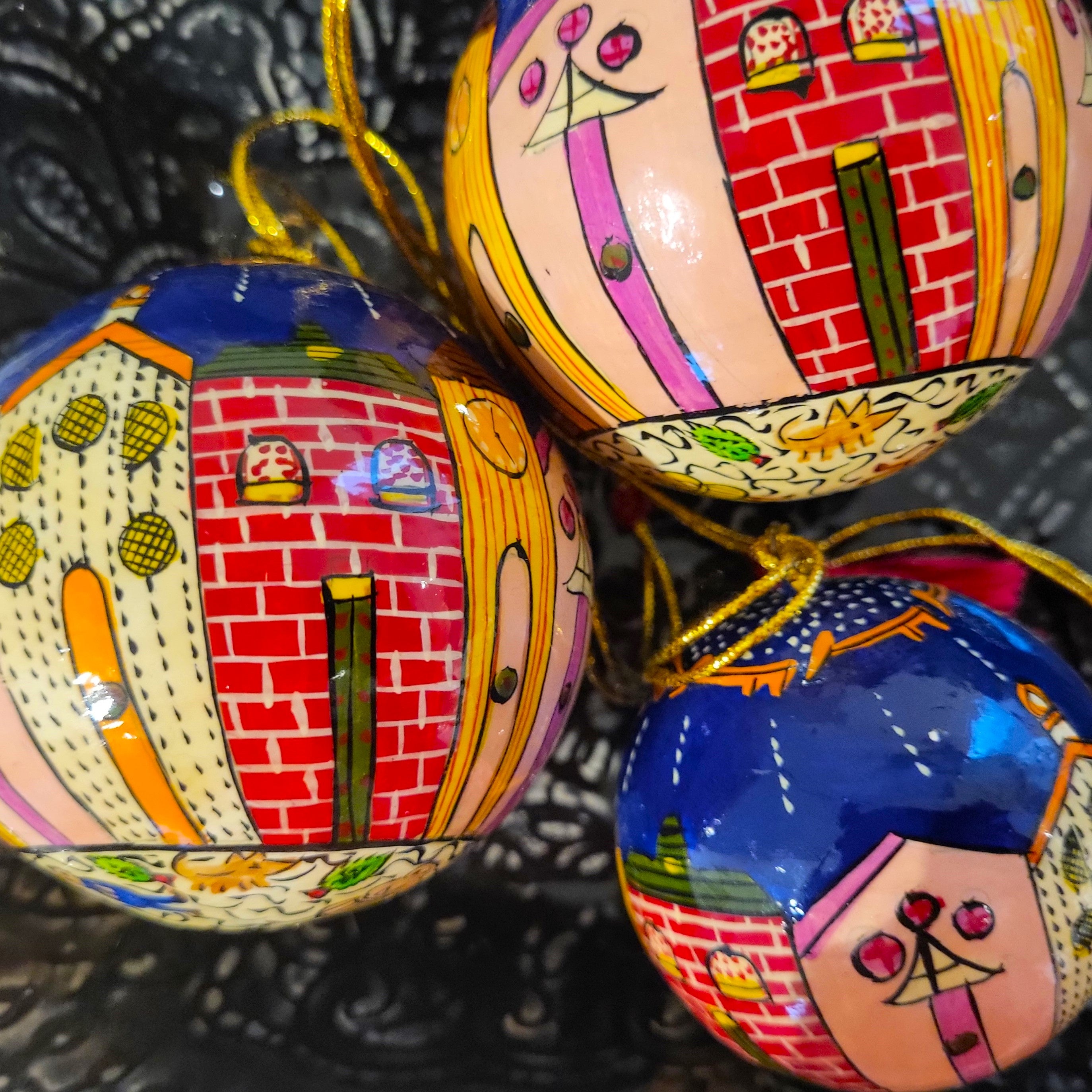Papier-mache Christmas bauble hand-painted with whimsical winter houses