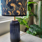 Bamboo-shade table lamp with a hand-painted tropical design on a teal base