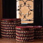 Raphia Lina Amber candle with hand-woven raffia exterior in natural, charcoal and red, amber scent