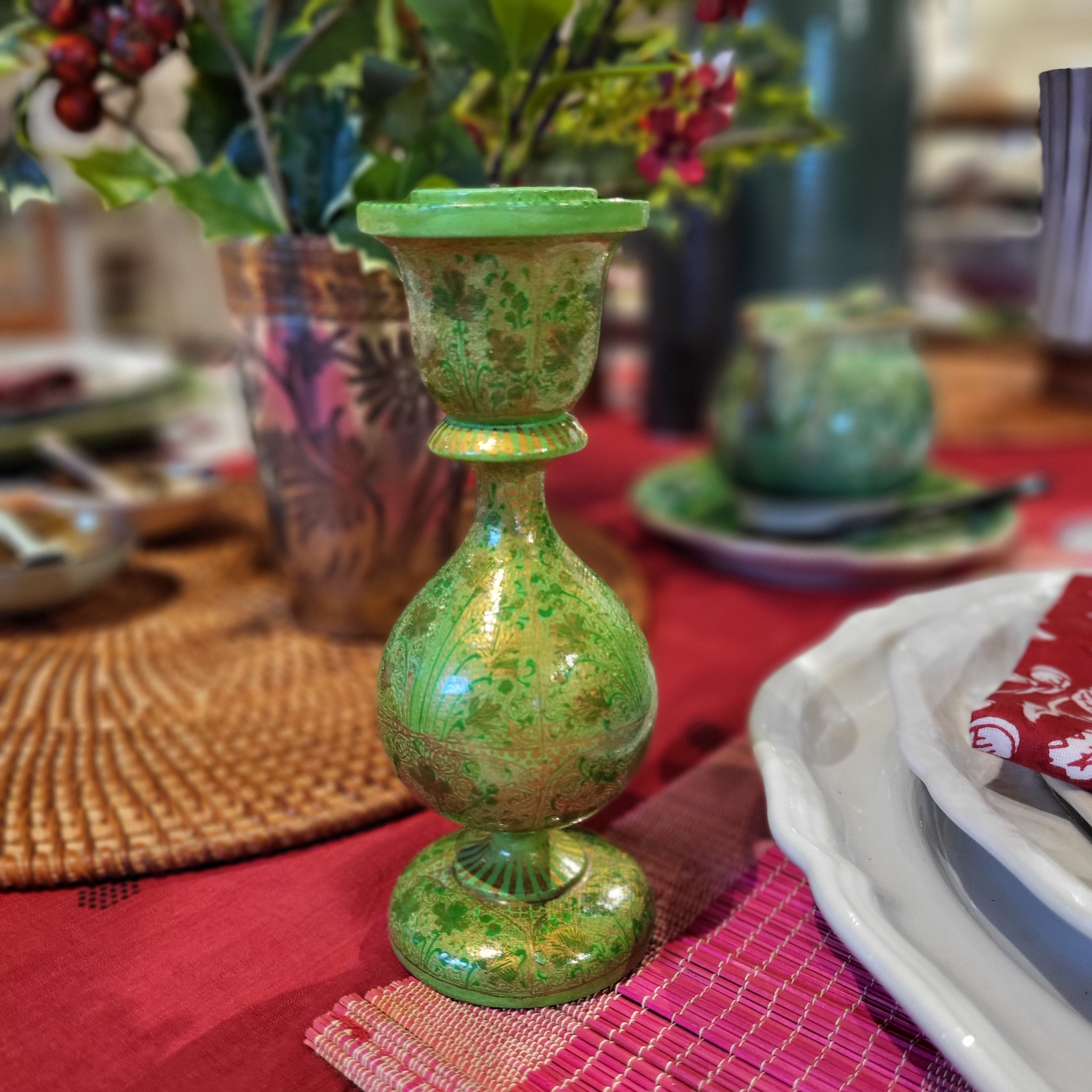 Hand painted candle stick on a red tablecloth