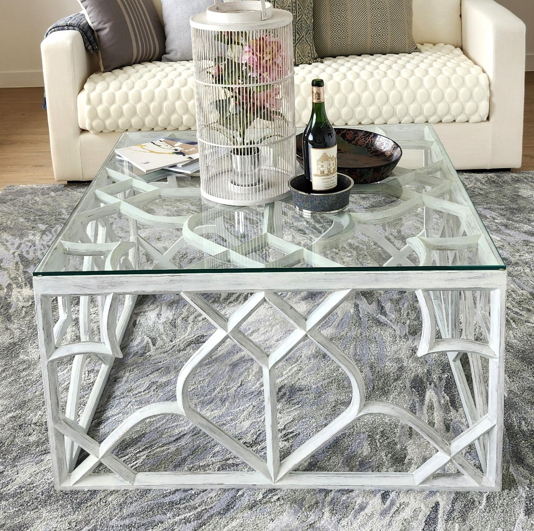 Carved mango wood trellis coffee table in distressed white with a glass top