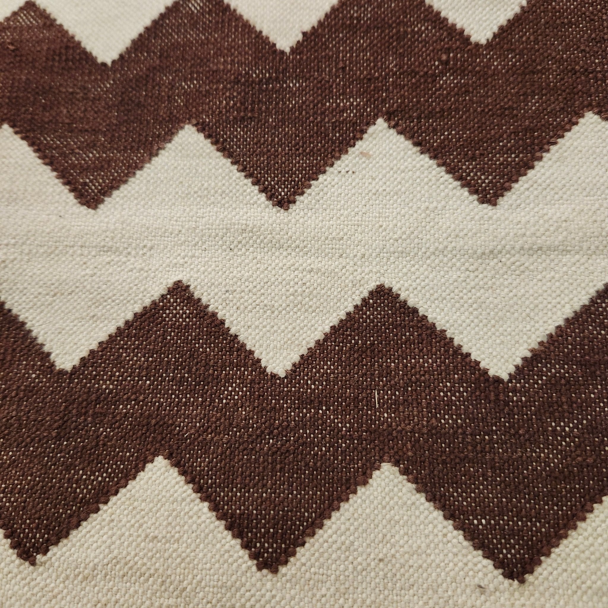 Zigzag-pattern cotton dhurry rug in brown and white, detail view