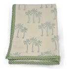 Baby blanket with palm tree pattern and green border on a white background