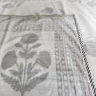 A soft cotton block print dohar or lightweight blanket with a poppy print in red on a white background