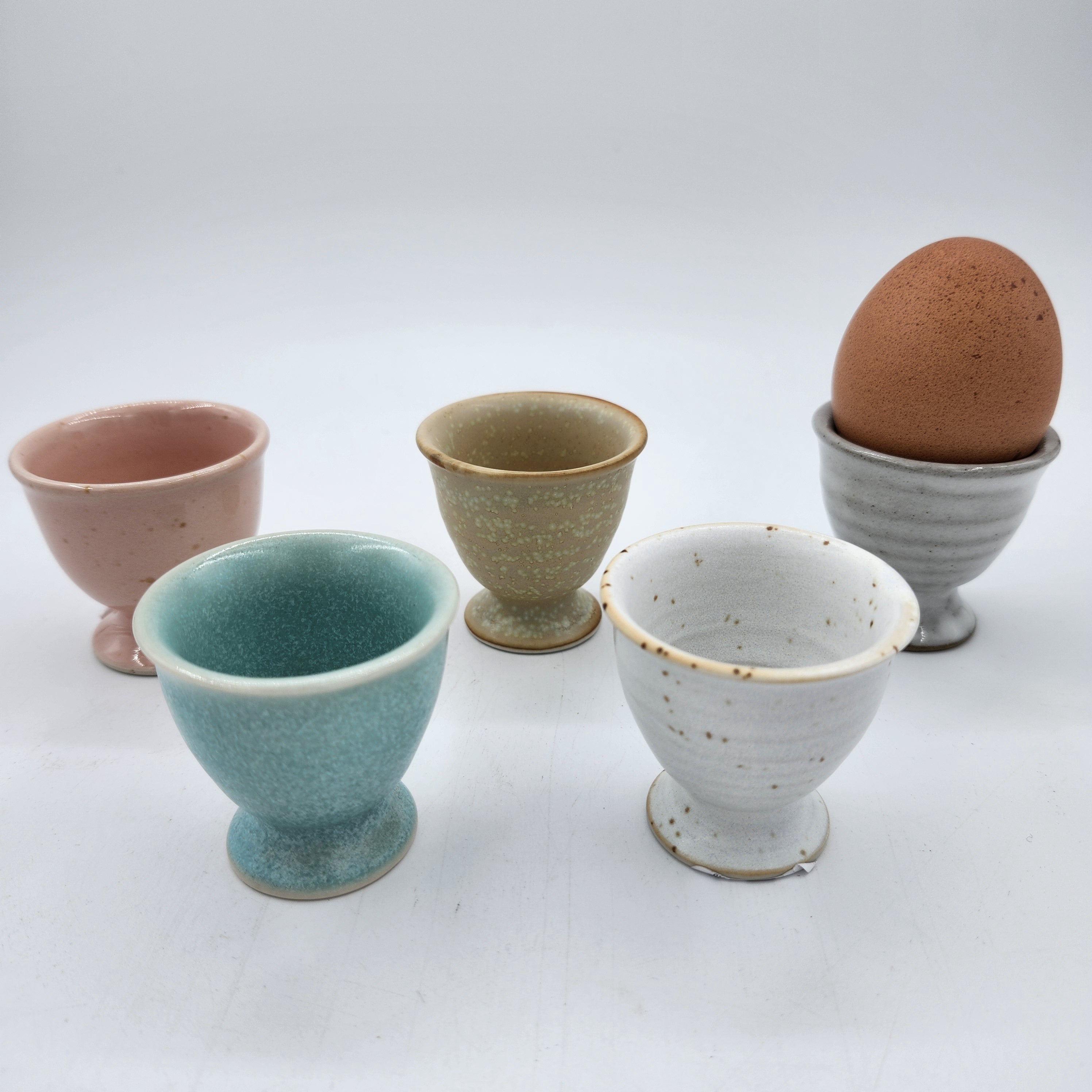 Ceramic egg cups in five pastel colours including grey, pink, taupe, teal and white, 5 cm diameter x 5 cm