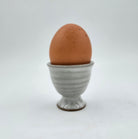 Grey ceramic egg cup with a boiled egg, 5 cm diameter x 5 cm