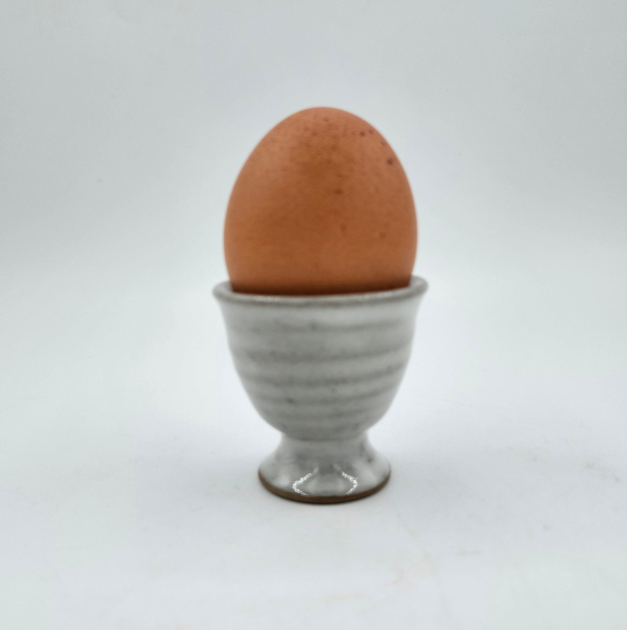 Grey ceramic egg cup with a boiled egg, 5 cm diameter x 5 cm