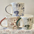 Set of three Willow pattern festive mugs in red, blue and green, fine bone china