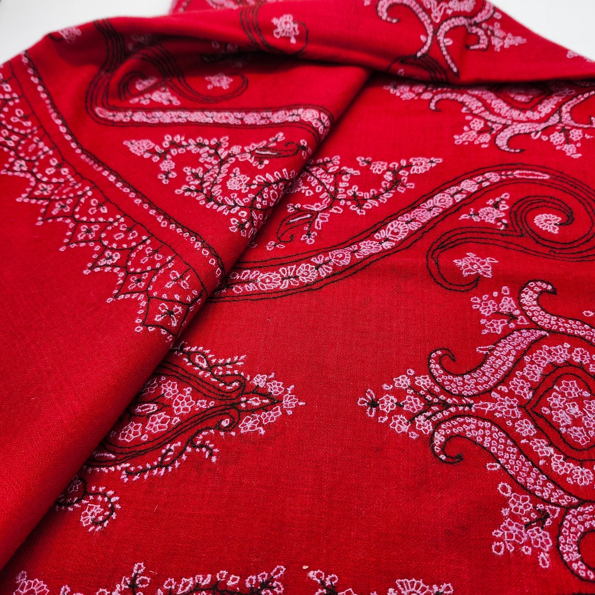Red pashmina shawl with black and white hand embroidery, detail view