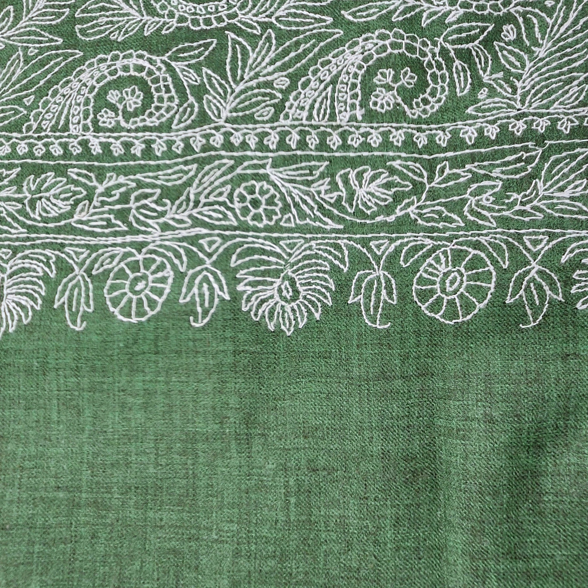 Detail of the white paisley hand embroidery worked on the green pashmina shawl, of which there is one piece.