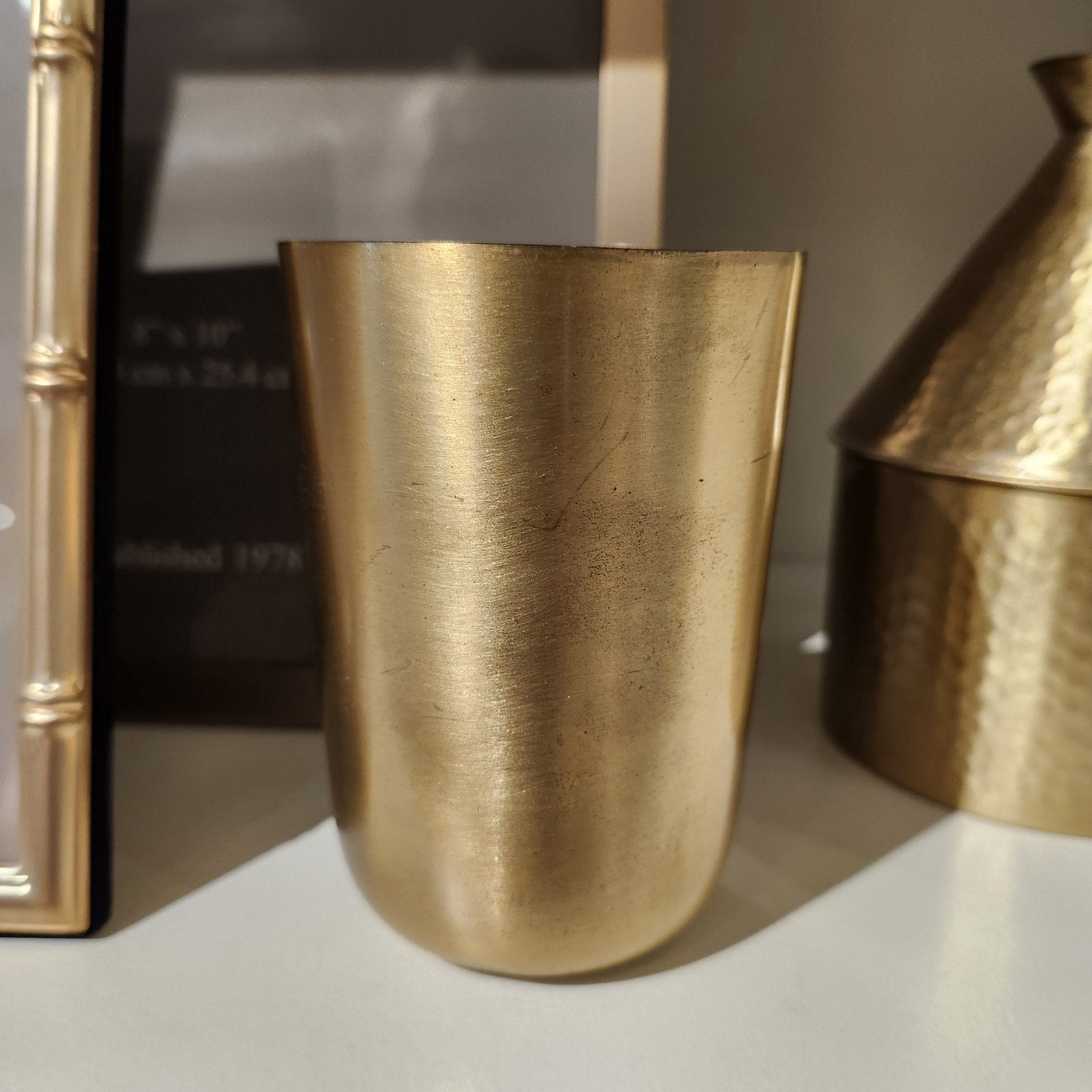 Solid brass tumbler, 10cm high by 7cm wide, with a smooth golden brass surface, for drinks